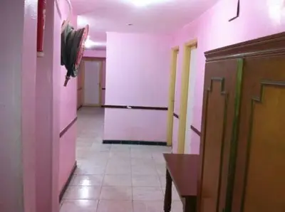 a hallway with pink walls and a tile floor at Nubian oasis hotel in Aswan
