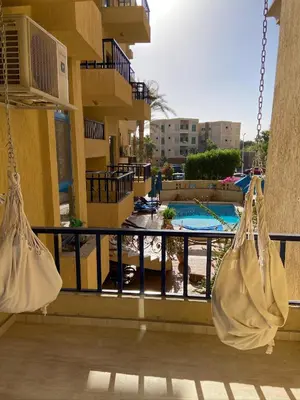 two white bags hanging from a balcony with a pool at Cordoba Suites in Hurghada