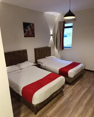 two beds sitting in a room with wood floors at Cordoba Suites in Hurghada