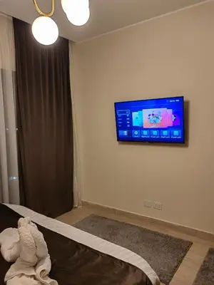 a room with a tv on a wall with a stuffed animal at Cordoba Suites in Hurghada