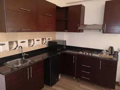a kitchen with dark brown cabinets and a sink at Cordoba Suites in Hurghada