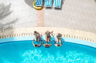 three girls in bathing suits jumping into a swimming pool at Blend Elphistone Resort Marsa Alam in Abu Dabab