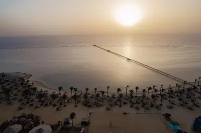 an aerial view of a beach with palm trees and a bridge at Blend Elphistone Resort Marsa Alam in Abu Dabab