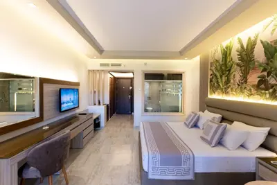 a hotel room with a bed and a flat screen tv at Ali Baba Palace Resort in Hurghada