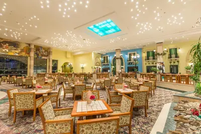 a restaurant with tables and chairs in a room at Ali Baba Palace Resort in Hurghada