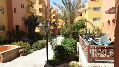 a courtyard of a apartment building with a bench and tables at Al Dora Residence Appartement in Hurghada