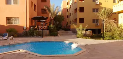 a swimming pool in a courtyard next to a building at Al Dora Residence Appartement in Hurghada