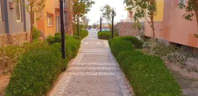 a cobblestone path between two buildings next to a street at Al Dora Residence Appartement in Hurghada