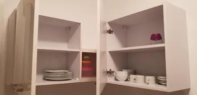 a white cabinet with plates and dishes in it at Al Dora Residence Appartement in Hurghada