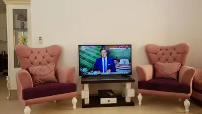 a living room with two chairs and a flat screen tv at Al Dora Residence Appartement in Hurghada