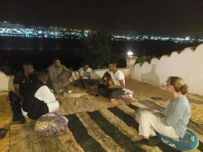 a group of people sitting on the ground at night at Maghrabi's Guest house in Aswan