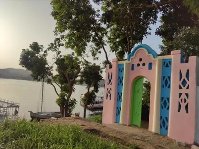 a small house with a door next to a body of water at Maghrabi's Guest house in Aswan