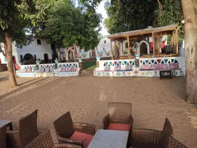 an outdoor seating area with tables and chairs in front of a building at Maghrabi's Guest house in Aswan