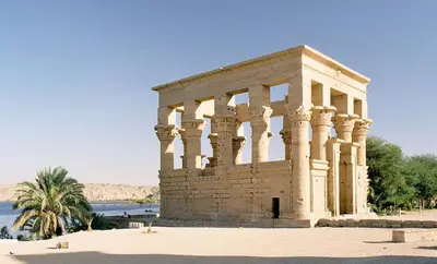 a stone building with columns in front of a body of water at Nile Cruise King Tut in Luxor