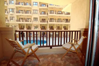 a balcony with two chairs and a swimming pool at SeaView Turtles in Hurghada