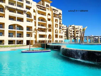 a swimming pool in front of a large building at Aldau Heights in Hurghada