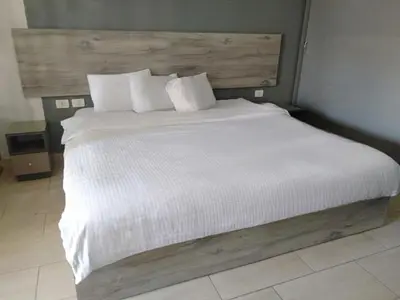 a bedroom with a white bed with a wooden headboard at Aldau Heights in Hurghada