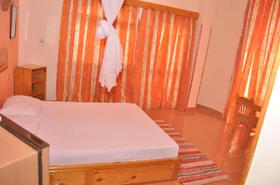 a bedroom with a bed and a window with a curtain at Ali Baba Safaga Hotel in Hurghada