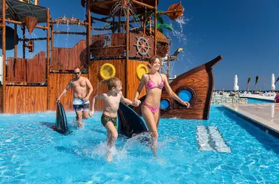 a group of people in the water at a water park at Three Corners Happy Life Beach Resort in Abu Dabab
