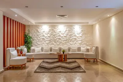 a living room with a white couch and a table at Three Corners Happy Life Beach Resort in Abu Dabab