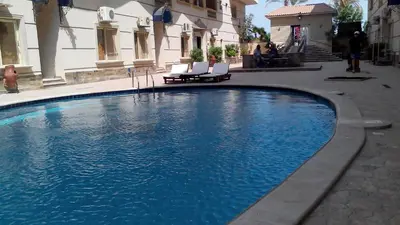 a swimming pool with two chairs and a building at The best holidays apartments in Hurghada in Hurghada