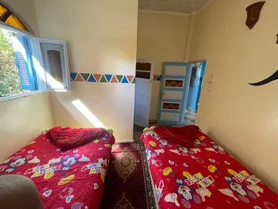 a bedroom with two beds in a room with a window at Shater Nubian House in Aswan