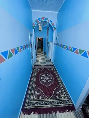 a hallway with a blue room with a rug on the floor at Shater Nubian House in Aswan