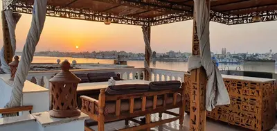a table on a balcony with a view of the sunset at Nile Sunrise Flats And Rooms in Luxor