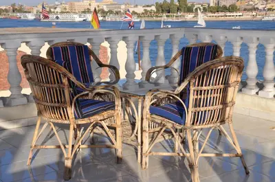two chairs and a table on a balcony at Nile Sunrise Flats And Rooms in Luxor