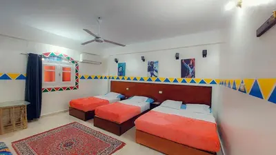 a bedroom with two beds and a ceiling fan at Bob Marley Guest House in Aswan