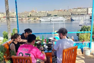 a group of people sitting at a table on a boat at Bob Marley Guest House in Aswan