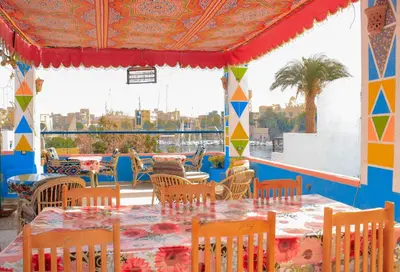 a restaurant with tables and chairs and a view of the city at Nuba Dool in Aswan