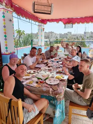 a group of people sitting around a table eating food at Nuba Dool in Aswan