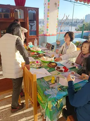 a group of people sitting around a table eating food at Nuba Dool in Aswan