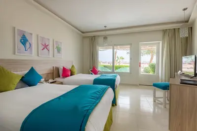 a hotel room with two beds and a television at Shams Lodge in Hurghada