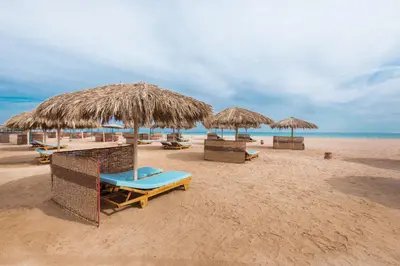 a group of chairs and umbrellas on a beach at Shams Lodge in Hurghada