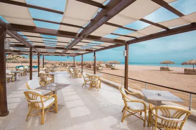 a patio with tables and chairs on the beach at Shams Lodge in Hurghada