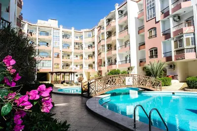 a large apartment building with a bridge over a swimming pool at Desert Pearl Art in Hurghada