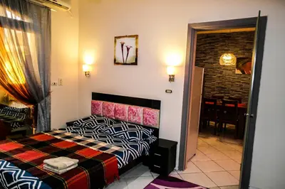 a bedroom with a bed and a dining room at Desert Pearl Art in Hurghada