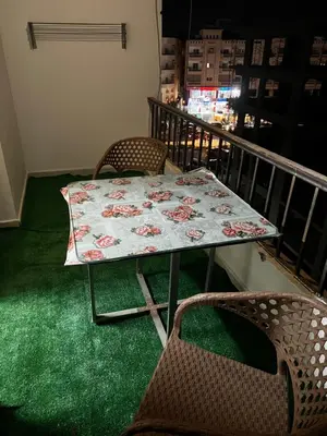 a table and chairs on a balcony with a blanket at Lotus compound in Hurghada