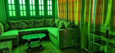 a living room with a green couch and a table at The Green Nubian House in Aswan