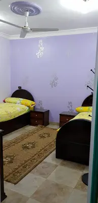 a bedroom with two beds and a ceiling at The Green Nubian House in Aswan