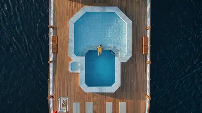 a man standing next to a swimming pool on a cruise ship at JAZ Elite Senator Nile Cruises - Every Thursday from Luxor for 07 Nights & Every Thursday from Luxor for 05 Nights in Luxor