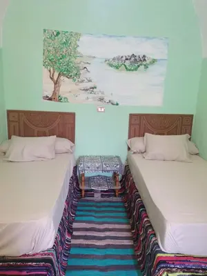 two beds sitting next to each other in a room at Aswan Nubian House in Aswan
