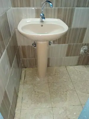 a white sink in a bathroom with a tiled floor at Aswan Nubian House in Aswan