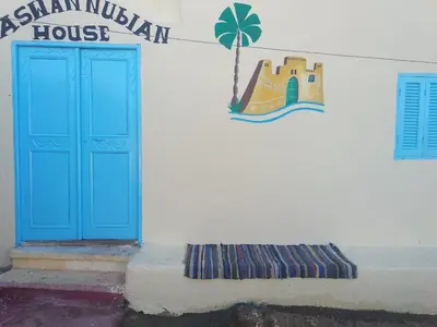 a building with a blue door and a sign on it at Aswan Nubian House in Aswan