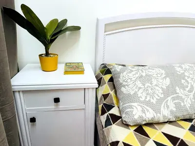 a plant on a nightstand next to a bed with a pillow at Karibu House Sheraton Road in Hurghada