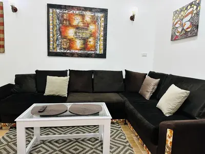 a black couch with a white coffee table in a living room at Karibu House Sheraton Road in Hurghada