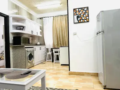 a kitchen with white cabinets and a white refrigerator at Karibu House Sheraton Road in Hurghada