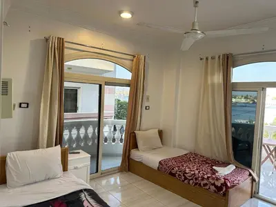 a bedroom with a bed and a window with a balcony at Soliman Nile View in Luxor